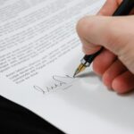 person signing in documentation paper