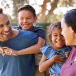 Família reunida ao ar livre, sorrindo e interagindo, representando bem-estar, convivência familiar e qualidade de vida no dia a dia.