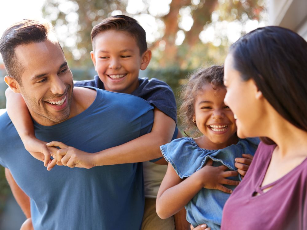 Família reunida ao ar livre, sorrindo e interagindo, representando bem-estar, convivência familiar e qualidade de vida no dia a dia.
